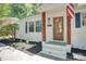 Charming front exterior featuring a wooden door, dark shutters, and landscaped yard at 4226 Raney Way, Charlotte, NC 28205