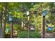 Collection of colorful birdhouses mounted on posts amidst lush green foliage at 4831 Antioch Church Rd, Matthews, NC 28104