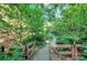Charming stone pathway leading through a beautiful, wooded garden with a wooden gate at 4831 Antioch Church Rd, Matthews, NC 28104