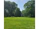 Expansive green lawn with mature trees surrounding a charming home at 6908 Alexander Rd, Charlotte, NC 28270