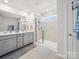 Well-lit bathroom showcasing a glass-enclosed shower, double vanity with gray cabinets, and tile flooring at 7032 Everly Commons Ln, Tega Cay, SC 29708