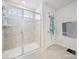 Bright bathroom with a glass-enclosed shower, tiled walls, and window for natural light at 7032 Everly Commons Ln, Tega Cay, SC 29708
