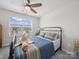 Cozy bedroom with a comfortable bed, ceiling fan, and a large window overlooking the neighborhood at 7032 Everly Commons Ln, Tega Cay, SC 29708