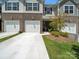Inviting townhome featuring a two-car garage, brick accents, and a cozy front porch at 7032 Everly Commons Ln, Tega Cay, SC 29708