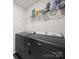 Functional laundry room featuring modern black appliances and shelving, offering convenience and organization at 7032 Everly Commons Ln, Tega Cay, SC 29708