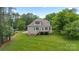 View of the back of the home featuring a wooden deck and a spacious green lawn at 704 Kenway Loop, Mooresville, NC 28117