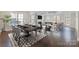 Open-concept living and dining area featuring hardwood floors, modern furniture, fireplace, and plenty of natural light at 704 Kenway Loop, Mooresville, NC 28117