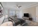 Comfortable main bedroom featuring a ceiling fan, large windows, a seating area, and plush bedding at 704 Kenway Loop, Mooresville, NC 28117