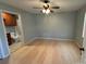 Bedroom features a ceiling fan and laminate flooring with a view into an attached bathroom at 72 Helens Way, Taylorsville, NC 28681