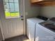 Bright laundry room featuring a modern washer and dryer next to an exterior door for convenience at 72 Helens Way, Taylorsville, NC 28681