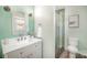 Bright bathroom featuring a shower with glass door, tile surround, and a decorative vanity at 8025 Cliffside Dr, Charlotte, NC 28270