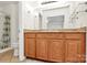 Bathroom vanity featuring wood cabinets, granite countertop, and a large mirror at 8062 Knights Bridge Rd, Charlotte, NC 28210