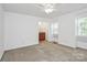 Bright bedroom featuring neutral carpet, a ceiling fan, and access to an ensuite bathroom at 8062 Knights Bridge Rd, Charlotte, NC 28210