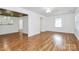 Open living room with hardwood floors, a ceiling fan, and natural light from a window at 8062 Knights Bridge Rd, Charlotte, NC 28210