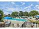 A community swimming pool with lounge chairs, umbrellas, and well maintained landscape at 8062 Knights Bridge Rd, Charlotte, NC 28210