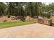 Outdoor stone patio area with built-in grill, surrounded by lawn and trees at 1074 Wylie Falls Ln, York, SC 29745