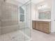 Modern bathroom with a glass-enclosed shower, tiled walls and floor, and a wooden vanity at 1074 Wylie Falls Ln, York, SC 29745