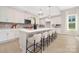 Kitchen featuring a large island with seating, pendant lights, white cabinets, and stainless steel appliances at 1074 Wylie Falls Ln, York, SC 29745
