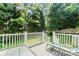 Spacious back deck with green space, features a white railing with lots of trees at 1109 Sunnyview Cir, Matthews, NC 28105