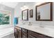 Bright bathroom features a double vanity with dark wood cabinets and decorative mirrors at 1109 Sunnyview Cir, Matthews, NC 28105