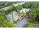 Aerial shot of the community amenities featuring tennis courts, a pool, and a parking area surrounded by trees at 1109 Sunnyview Cir, Matthews, NC 28105