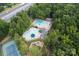 Aerial view of the community pool area, complete with pools, seating, playground, and mature trees at 1109 Sunnyview Cir, Matthews, NC 28105