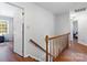 Hallway with hardwood floors, wooden railings, and multiple doors at 1109 Sunnyview Cir, Matthews, NC 28105