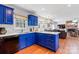 Bright kitchen with bold blue cabinets, modern appliances, and hardwood floors at 1109 Sunnyview Cir, Matthews, NC 28105
