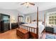 Spacious bedroom featuring a four-poster bed, hardwood floors, and ample natural light at 1109 Sunnyview Cir, Matthews, NC 28105
