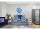 Cozy living room with gray sofa, basketball-themed decor, and stainless steel refrigerator at 1113 Greenleaf Ave # A, Charlotte, NC 28202