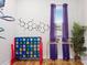 Colorful playroom with unique wall art, large window with purple curtains, and games at 1113 Greenleaf Ave # A, Charlotte, NC 28202