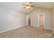 Cozy carpeted bedroom with a ceiling fan and access to the walk-in closet at 11531 Delores Ferguson Ln, Charlotte, NC 28277
