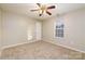 Comfortable carpeted bedroom featuring a ceiling fan, window and closet door at 11531 Delores Ferguson Ln, Charlotte, NC 28277