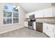 Kitchen with stainless steel appliances, white cabinets, and large arched window at 11531 Delores Ferguson Ln, Charlotte, NC 28277