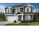 Charming two-story home with gray siding, white trim, a two-car garage, and a well-manicured front lawn at 12591 Forager Pl # 92, Midland, NC 28107