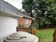 Exterior view showcasing the home's siding, brick, and a glimpse of the landscaped backyard with hot tub at 1344 Moonshadow Ln, Shelby, NC 28150