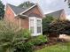 Charming brick home exterior with a bay window and mature garden landscaping at 1344 Moonshadow Ln, Shelby, NC 28150