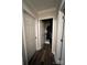 Hallway with multiple doors, wood-look floors, and white trim at 1344 Moonshadow Ln, Shelby, NC 28150