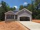 New construction home featuring a gray exterior, covered porch, and attached garage at 153 Brook Creek Dr, Troutman, NC 28166