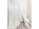 Bathroom featuring a glass-enclosed shower and white toilet, with laminate flooring at 1818 Stowe Ave, Gastonia, NC 28054