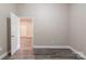 A clean bedroom with neutral walls, laminate flooring, and a door leading to the next room at 1818 Stowe Ave, Gastonia, NC 28054
