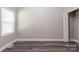 A neutral bedroom space featuring a closet, laminate flooring, and window with natural light at 1818 Stowe Ave, Gastonia, NC 28054