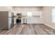 Well-lit kitchen with stainless steel appliances, white cabinets, and modern flooring at 1818 Stowe Ave, Gastonia, NC 28054