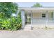 Side porch featuring white railing, gray painted brick supports, and manicured green foliage at 1818 Stowe Ave, Gastonia, NC 28054
