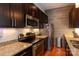 This condo kitchen features stainless steel appliances, granite countertops, and modern dark wood cabinets at 2116 Mcclintock Rd # 122, Charlotte, NC 28205