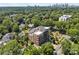An aerial view of a modern building surrounded by green trees, residential homes, and city skyline at 2312 Selwyn Ave # 502, Charlotte, NC 28207