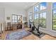 Bright bonus room with large windows, desk, and exercise bike with hardwood floors and neutral color scheme at 2312 Selwyn Ave # 502, Charlotte, NC 28207