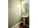 Modern half bathroom featuring a pedestal sink, decorative mirror, and wood-look flooring at 243 Kerri Dawn Ln, Locust, NC 28097