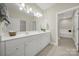 Bathroom with double vanity, white cabinets, and tiled floor with bathtub visible in the background at 2959 Bellasera Way, Matthews, NC 28105