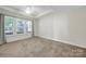 Spacious carpeted bedroom with tray ceiling, large window, and neutral color palette at 2959 Bellasera Way, Matthews, NC 28105